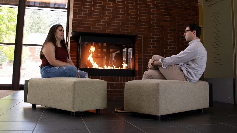 University of Oregon College of Education students sitting in HEDCO lobby by fireplace