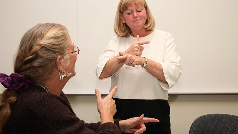 University of Oregon College of Education professor teaching American Sign Language to student University of Oregon College of Education professor teaching American Sign Language to student