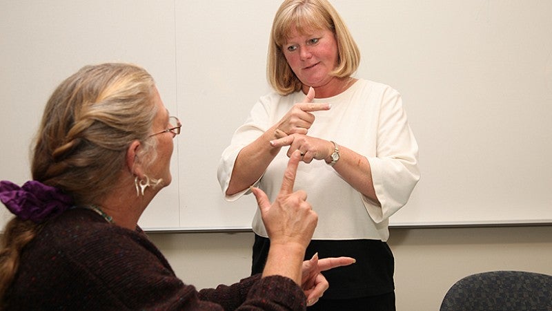 University of Oregon College of Education professor teaching American Sign Language to student