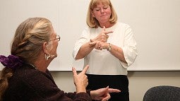 University of Oregon College of Education professor teaching American Sign Language to student University of Oregon College of Education professor teaching American Sign Language to student