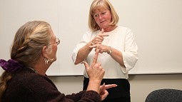University of Oregon College of Education professor teaching American Sign Language to student University of Oregon College of Education professor teaching American Sign Language to student